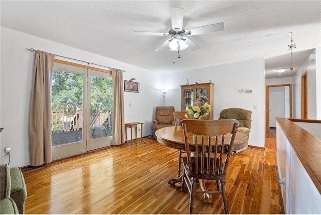 dining space with light hardwood / wood-style floors, a textured ceiling, and ceiling fan