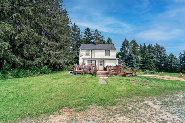 rear view of house featuring a deck and a yard