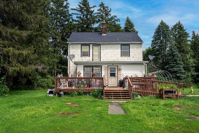 rear view of property with a yard and a wooden deck