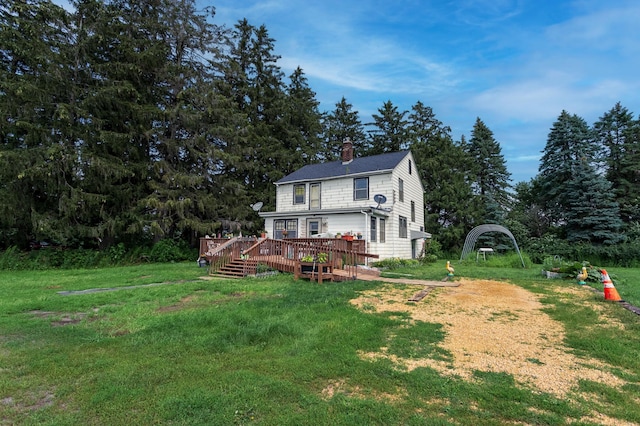 rear view of house featuring a deck and a lawn