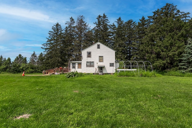 rear view of house featuring a lawn