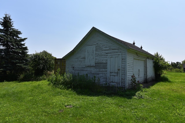 view of side of property featuring a yard and an outdoor structure