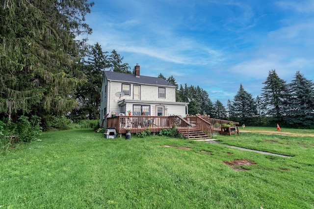 back of property with a wooden deck and a yard