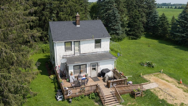 rear view of property featuring a yard and a deck