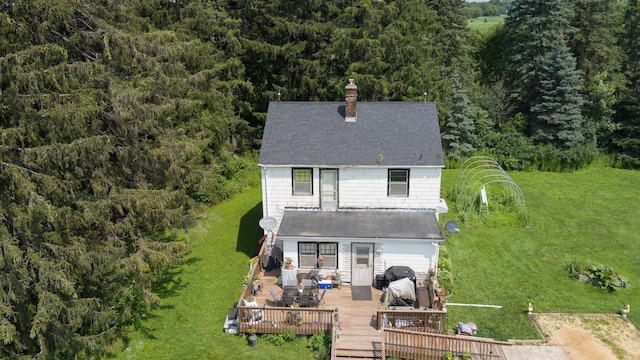 rear view of house featuring a wooden deck and a yard