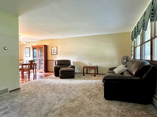 carpeted living room featuring a chandelier, visible vents, and baseboards