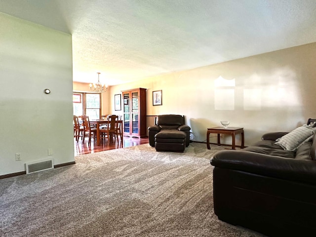 carpeted living area with a textured ceiling, a chandelier, visible vents, and baseboards