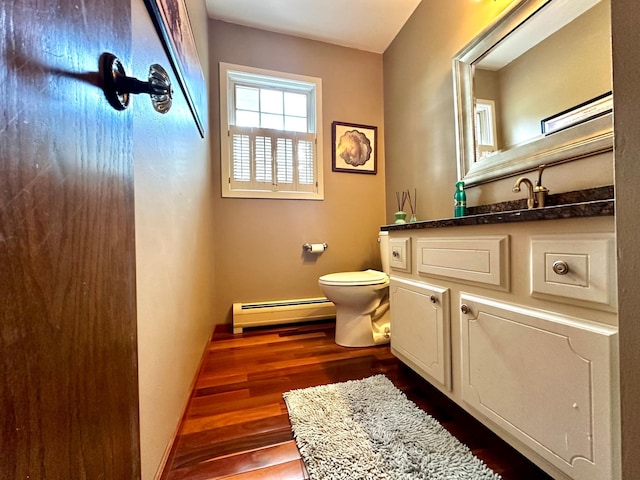 half bathroom with baseboards, toilet, a baseboard radiator, wood finished floors, and vanity