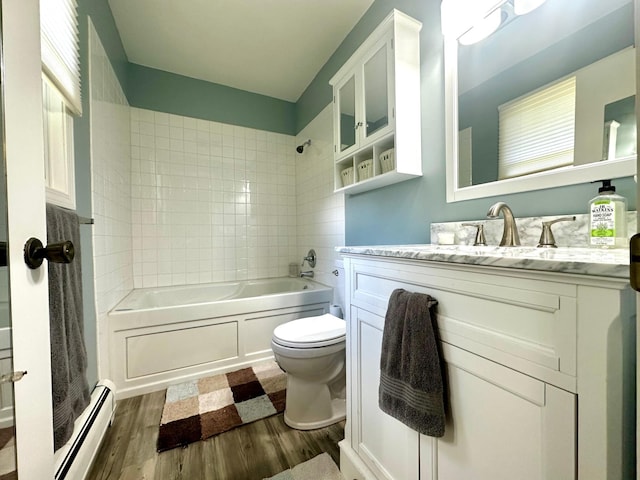 bathroom featuring a baseboard radiator, toilet, wood finished floors, vanity, and a shower