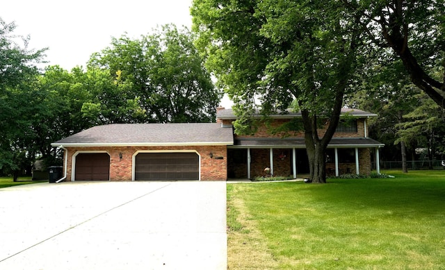 view of front facade with an attached garage, driveway, a front lawn, and brick siding