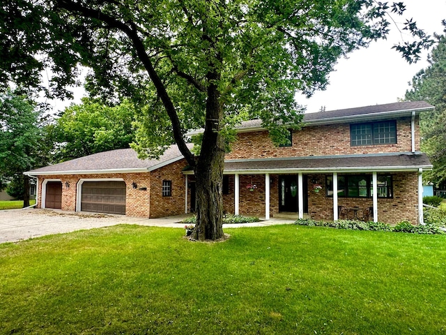 traditional-style house with a garage, driveway, a front lawn, and brick siding