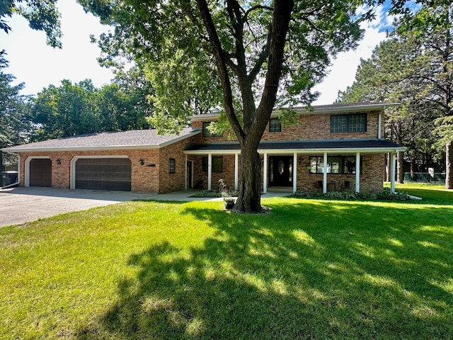 view of front facade featuring a garage, a front lawn, concrete driveway, and brick siding