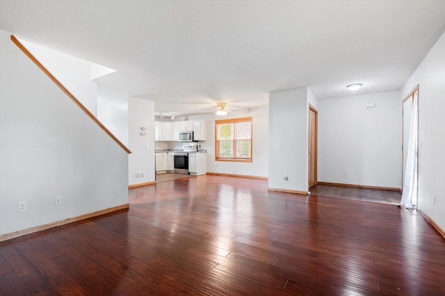 unfurnished living room featuring ceiling fan and dark hardwood / wood-style flooring