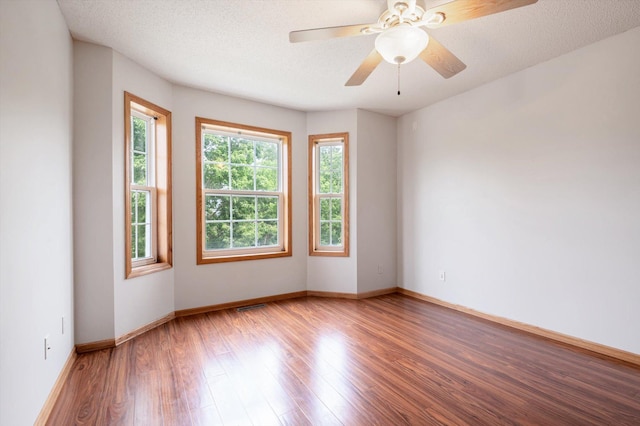 unfurnished room with ceiling fan, hardwood / wood-style flooring, and a textured ceiling