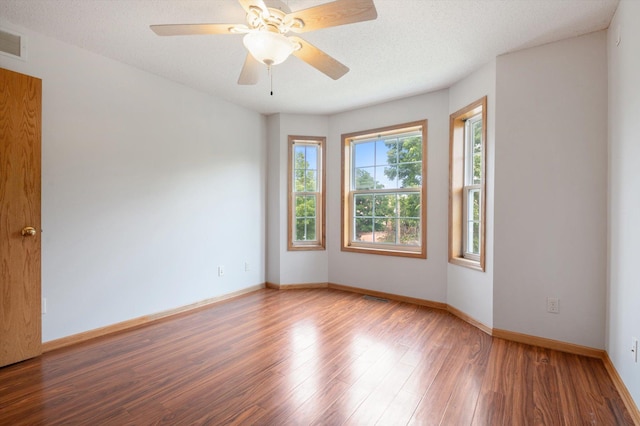 spare room featuring hardwood / wood-style flooring, ceiling fan, and a textured ceiling