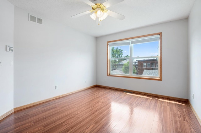 empty room featuring hardwood / wood-style floors, a textured ceiling, and ceiling fan