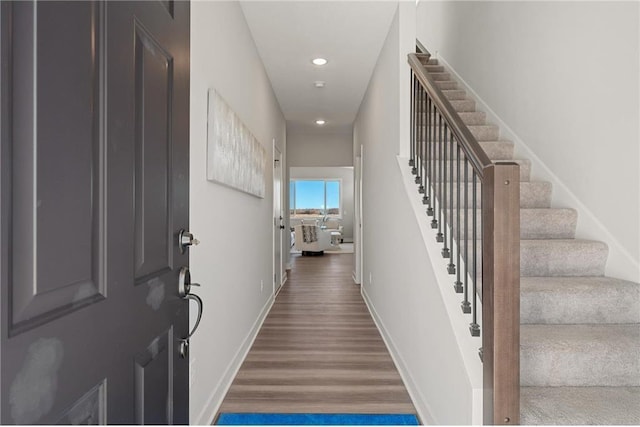 foyer with stairway, baseboards, wood finished floors, and recessed lighting