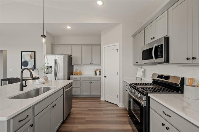 kitchen featuring stainless steel appliances, gray cabinets, dark wood-type flooring, and a sink