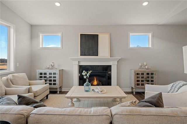 living area featuring a high end fireplace, baseboards, recessed lighting, and wood finished floors