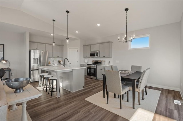 dining room featuring lofted ceiling, a chandelier, recessed lighting, dark wood-style flooring, and baseboards