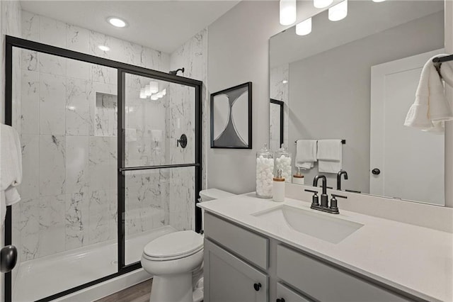 full bathroom with a stall shower, vanity, and toilet