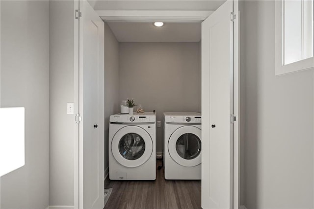 clothes washing area featuring laundry area, dark wood-style flooring, and washing machine and clothes dryer