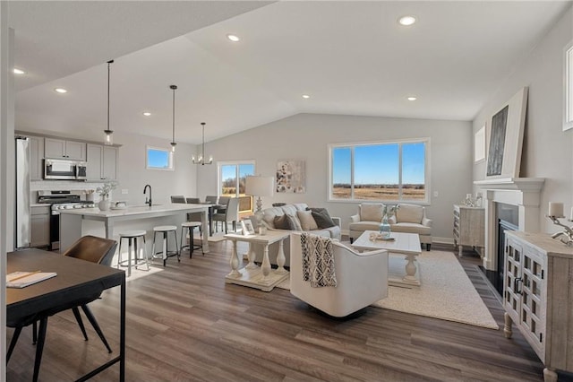 17041 Uranimite NW, Ramsey, MN 55303 - living room with lofted ceiling, dark wood-style flooring, a fireplace with flush hearth, recessed lighting, and a chandelier