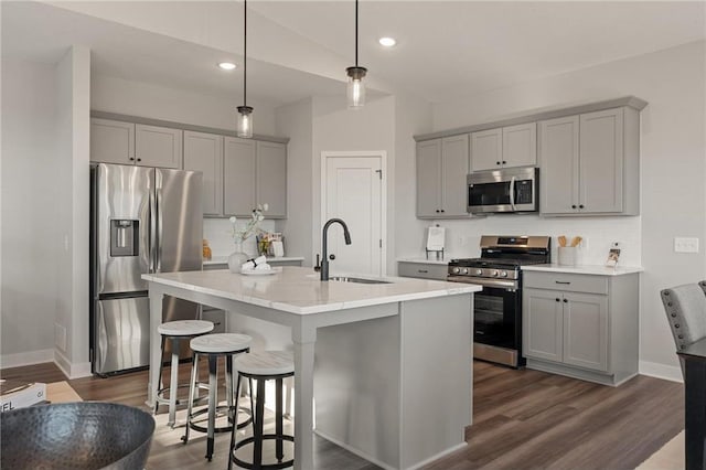 17041 Uranimite NW, Ramsey, MN 55303 - kitchen with appliances with stainless steel finishes, gray cabinetry, backsplash, a breakfast bar area, and recessed lighting