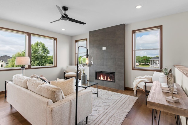 living room featuring a tile fireplace, a wealth of natural light, and hardwood / wood-style floors