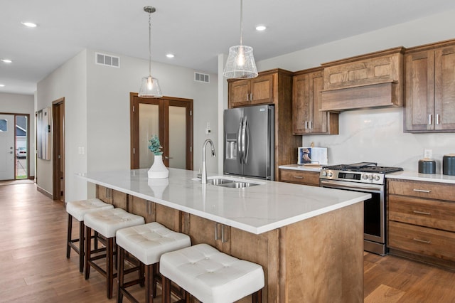 kitchen featuring sink, dark wood-type flooring, an island with sink, and stainless steel appliances