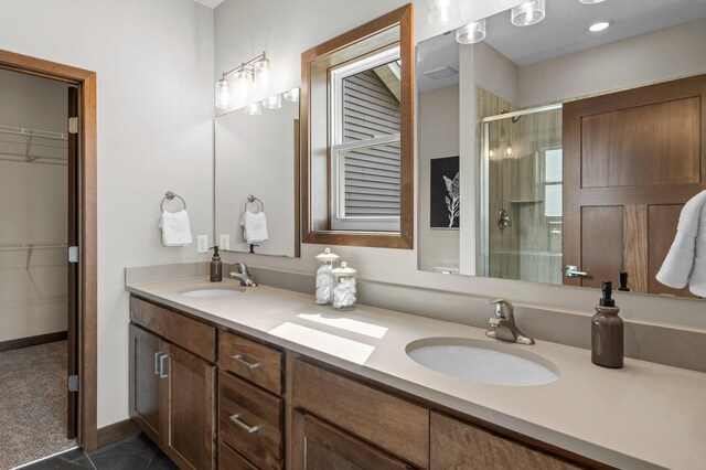 bathroom featuring a shower with door, tile patterned flooring, and double vanity