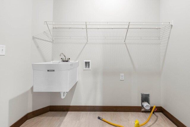 laundry room with sink, wood-type flooring, and washer hookup