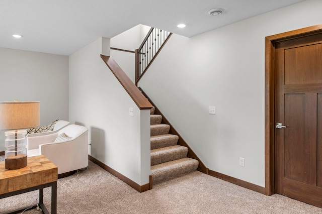 stairs featuring light colored carpet