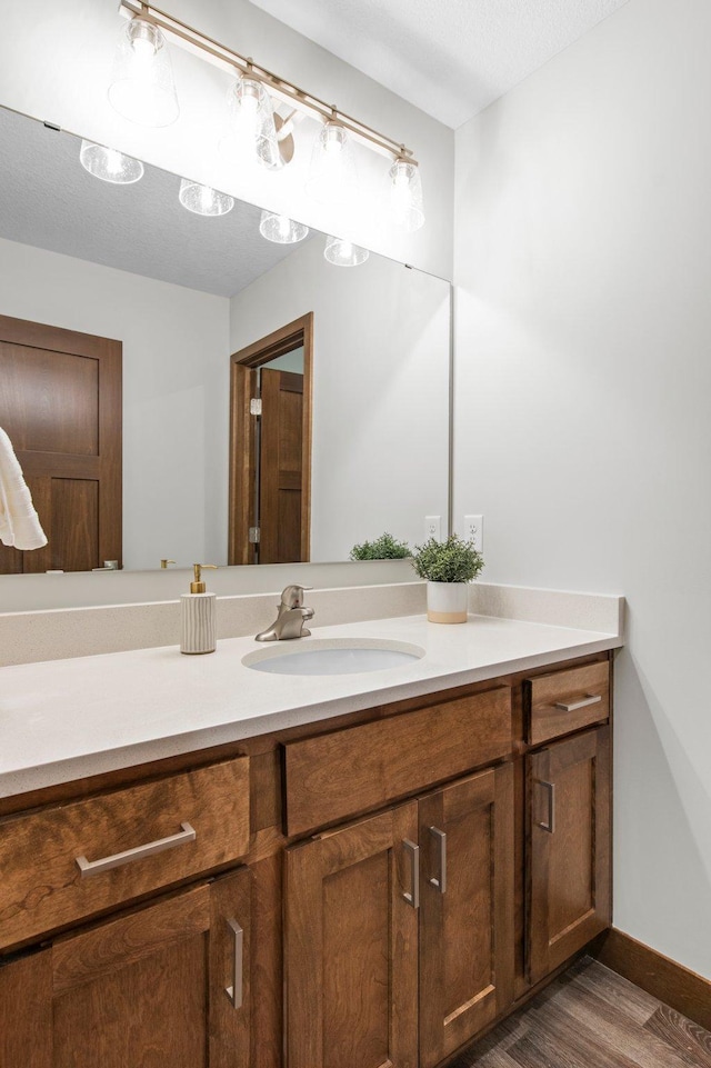 bathroom featuring vanity, a textured ceiling, and hardwood / wood-style flooring