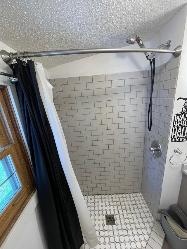 bathroom with a textured ceiling, tile patterned flooring, and curtained shower