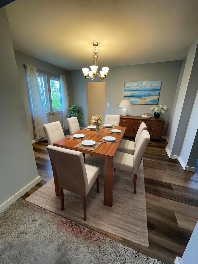 dining space featuring dark hardwood / wood-style flooring and a chandelier