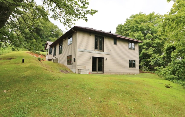 rear view of property featuring a lawn