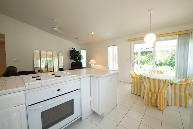 kitchen featuring white cabinetry, tile countertops, white appliances, and pendant lighting