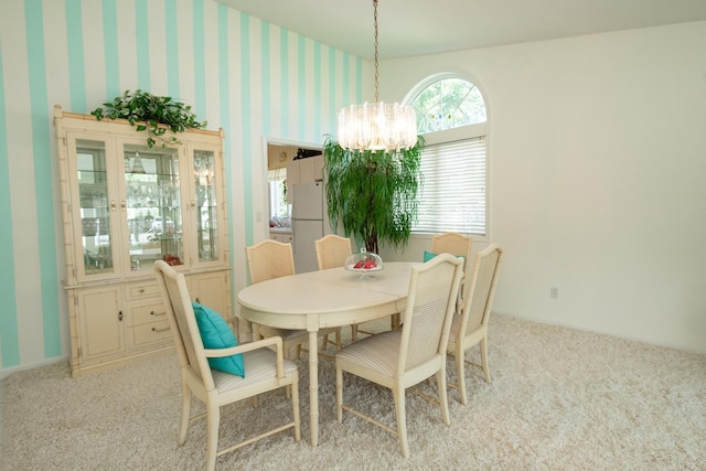 dining area with a chandelier and light carpet