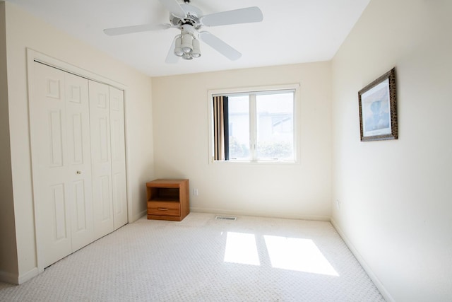 unfurnished bedroom featuring ceiling fan, carpet, and a closet