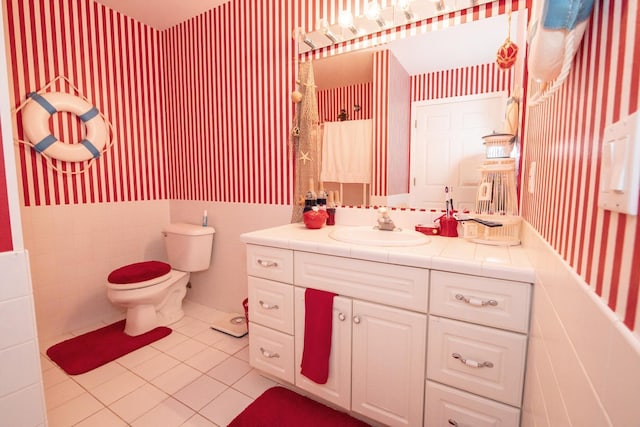 bathroom featuring tile walls, tile patterned floors, toilet, and vanity