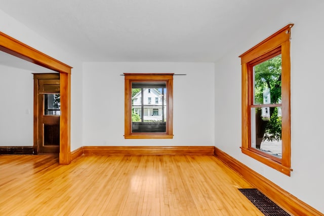 unfurnished room with light hardwood / wood-style floors and plenty of natural light