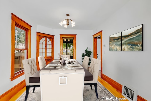 dining room featuring light hardwood / wood-style floors and a chandelier