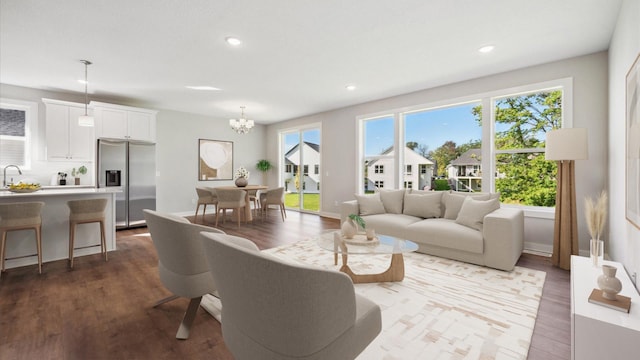 living room with sink, an inviting chandelier, a wealth of natural light, and hardwood / wood-style floors