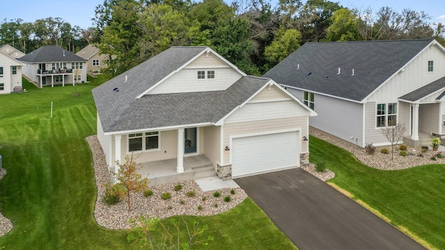 view of front of home with a garage, a porch, and a front lawn