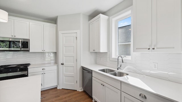 kitchen with stainless steel appliances, backsplash, and white cabinets