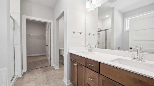 bathroom featuring toilet, walk in shower, and vanity