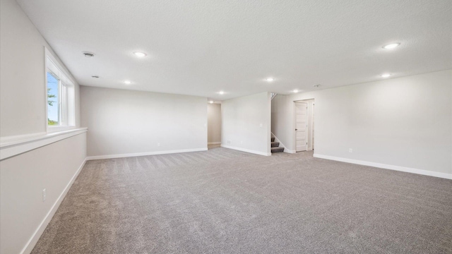 basement featuring a textured ceiling and carpet