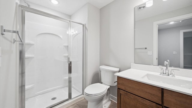 bathroom featuring toilet, tile patterned flooring, walk in shower, and vanity