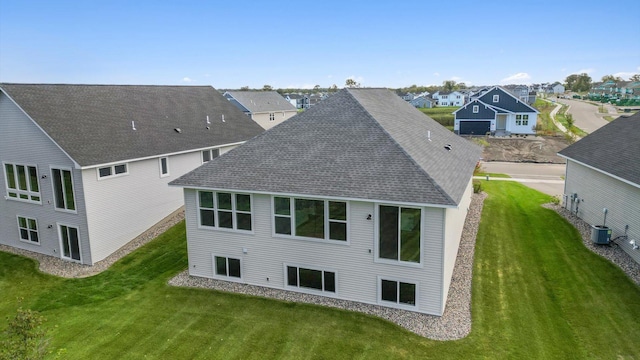 rear view of house with a yard and central air condition unit